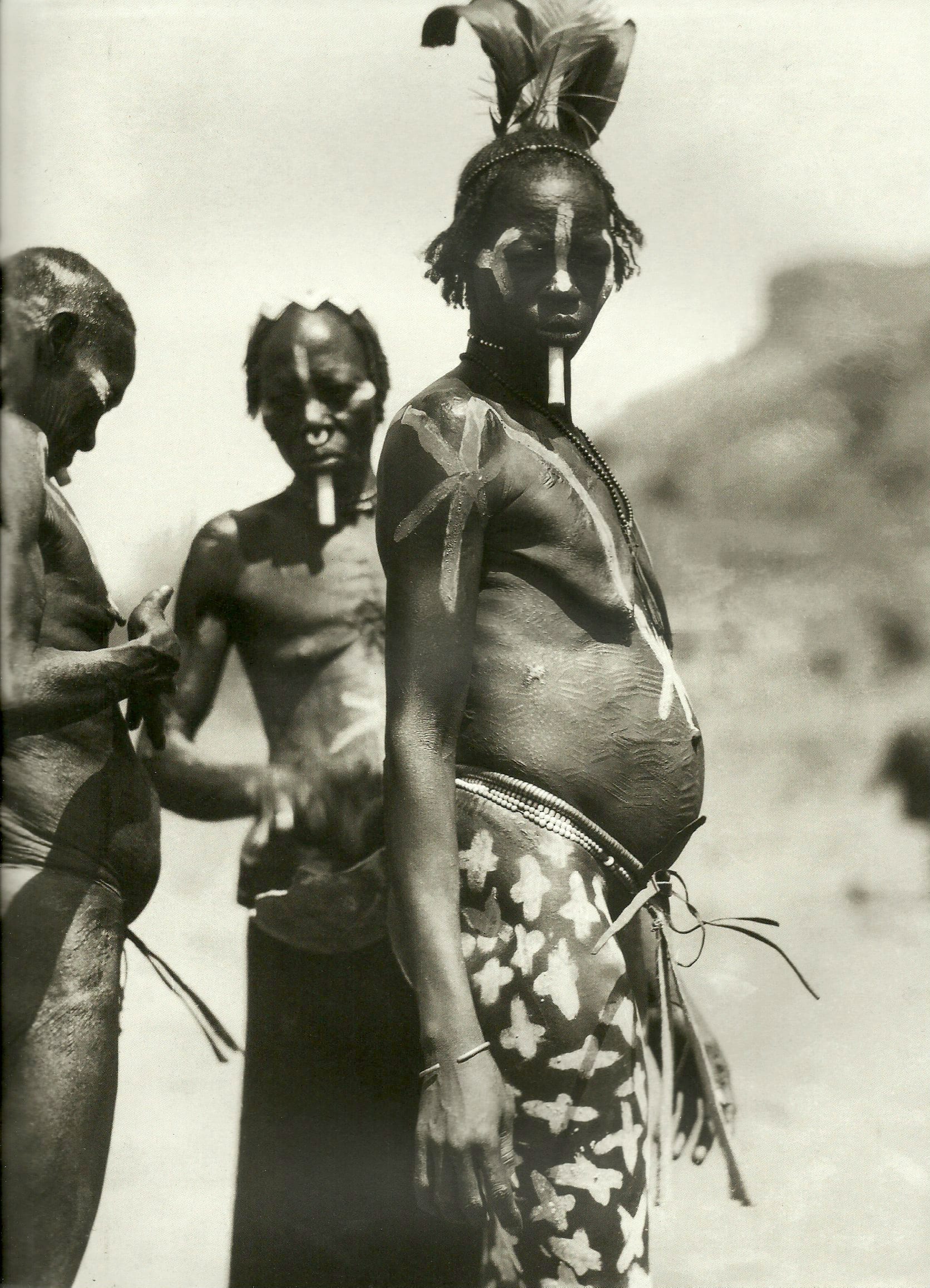 The painting and ornaments on the Nuba woman's face and body